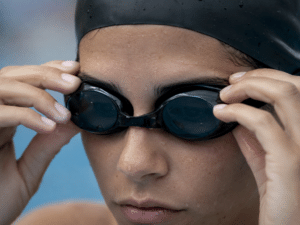 Persona ajustando sus antiparras de natación verificando el ajuste correcto antes de nadar