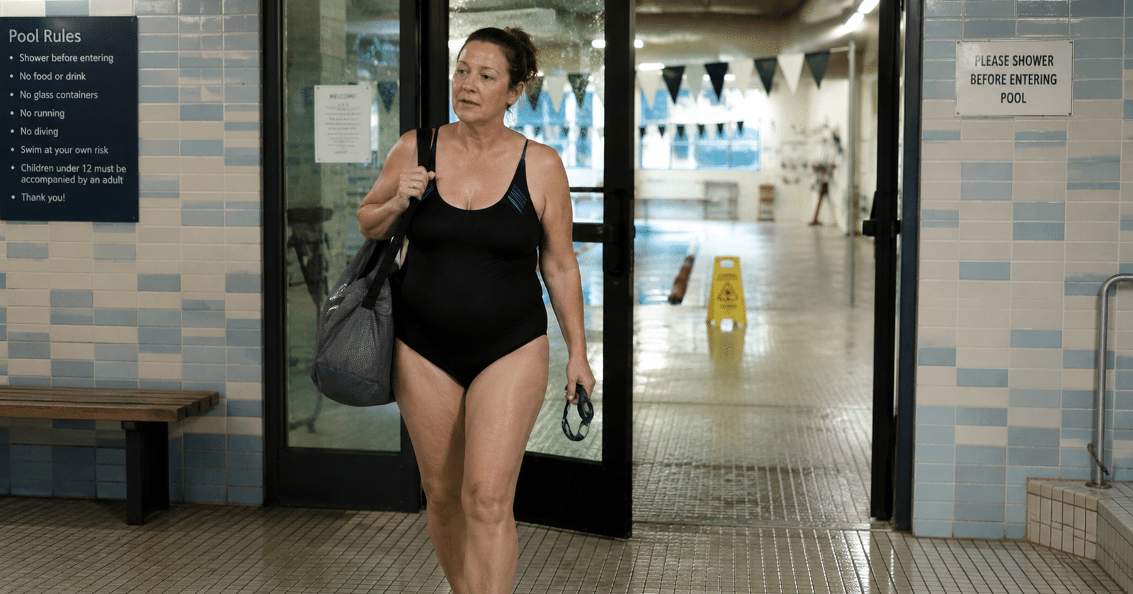 Nadador adulto llegando al natatorio con su mochila antes de la sesión