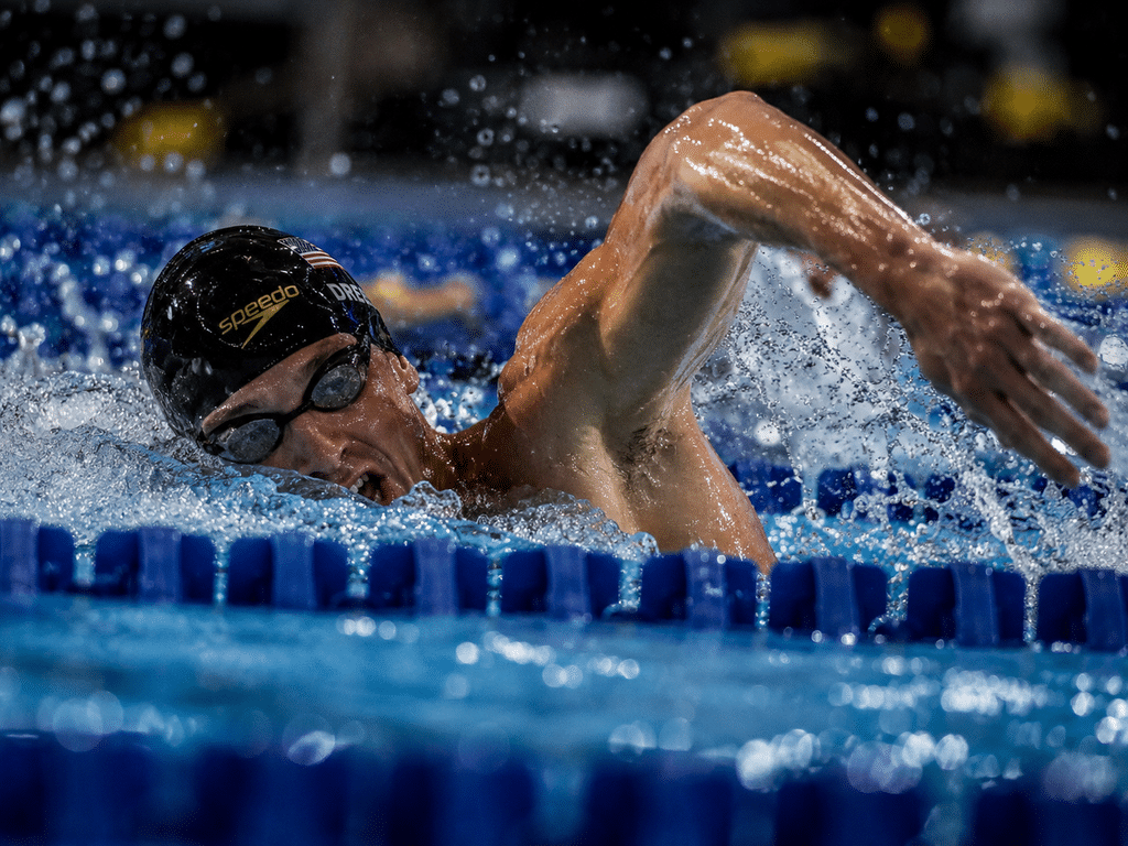 Nadador en plena carrera con tech suit aprobado por World Aquatics en pileta cubierta
