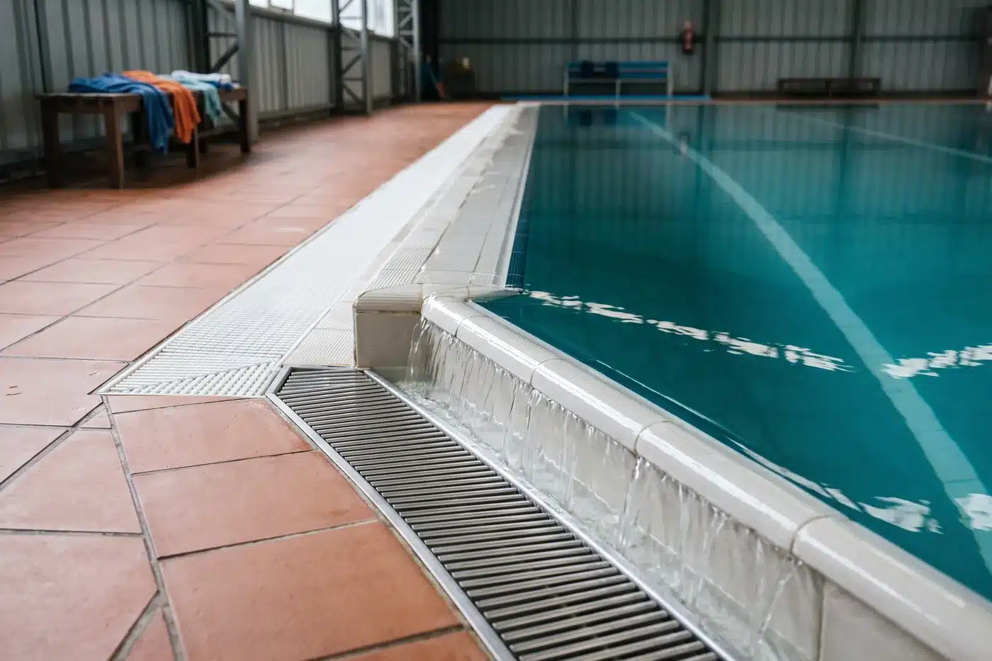 Canaleta perimetral de una pileta con el agua desbordando pareja